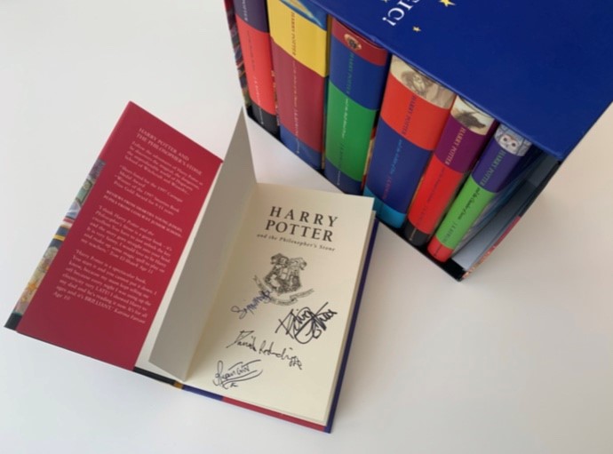 Full boxed set of the Harry Potter children's books by J.K. Rowling, all first editions signed by Daniel Radcliffe, Rupert Grint, Emma Watson, and Robbie Coltrane